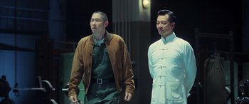 Movie still from “Ip Man 4: The Finale” (2019), directed by Wilson Yip – Two men standing next to each other on a street; Medium shot, Low angle