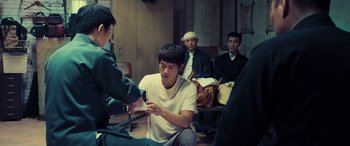 Movie still from “Ip Man 4: The Finale” (2019), directed by Wilson Yip – A group of men sitting in a room; Medium shot, High angle