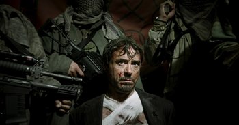 Movie still from “Iron Man” (2008), directed by Jon Favreau – A man with bandages on his face and bandages on his face; Medium shot, Low angle