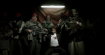 Movie still from “Iron Man” (2008), directed by Jon Favreau – A group of men in military fatigues holding guns; Wide shot, Low angle