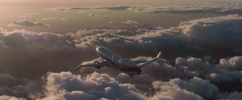Movie still from “Iron Man” (2008), directed by Jon Favreau – An airplane is flying through the clouds in the sky; Extreme Wide shot, Low angle