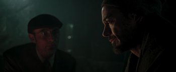 Movie still from “Iron Man” (2008), directed by Jon Favreau – A man with a goatee stares into the distance; Close Up shot, Over the shoulder angle