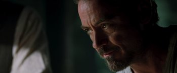 Movie still from “Iron Man” (2008), directed by Jon Favreau – A man with a beard looking to his left; Close Up shot, Over the shoulder angle