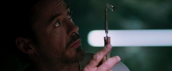Movie still from “Iron Man” (2008), directed by Jon Favreau – A person holding a pair of scissors; Extreme Close Up shot, Low angle