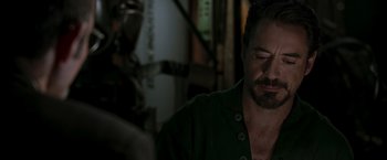 Movie still from “Iron Man” (2008), directed by Jon Favreau – A person with his eyes closed; Close Up shot, Over the shoulder angle