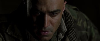 Movie still from “Iron Man” (2008), directed by Jon Favreau – A man's face in the dark; Close Up shot, Over the shoulder angle