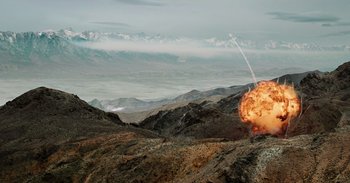 Movie still from “Iron Man” (2008), directed by Jon Favreau – An image of an explosion in the middle of a mountain range; Extreme Wide shot, Low angle