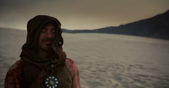 Movie still from “Iron Man” (2008), directed by Jon Favreau – A man with a beard is wearing an iron man costume; Close Up shot, Over the shoulder angle