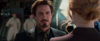 Movie still from “Iron Man” (2008), directed by Jon Favreau – A person wearing a suit and tie; Close Up shot, Over the shoulder angle