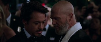 Movie still from “Iron Man” (2008), directed by Jon Favreau – A man in a suit and a man in a tie; Close Up shot, Over the shoulder angle