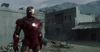 Movie still from “Iron Man” (2008), directed by Jon Favreau – A man in a suit of iron man standing in front of an abandoned building; Wide shot, Low angle