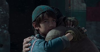 Movie still from “Iron Man” (2008), directed by Jon Favreau – A young boy holding a stuffed animal in his arms; Close Up shot, Low angle