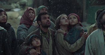 Movie still from “Iron Man” (2008), directed by Jon Favreau – A group of people standing in the snow looking up at the sky; Medium shot, Low angle