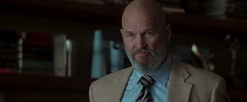 Movie still from “Iron Man” (2008), directed by Jon Favreau – A man with a beard wearing a suit and tie; Close Up shot, Low angle