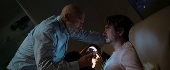 Movie still from “Iron Man” (2008), directed by Jon Favreau – A man and a man with a light in a room; Close Up shot, Over the shoulder angle