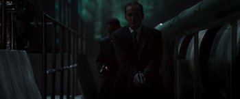 Movie still from “Iron Man” (2008), directed by Jon Favreau – A man in a suit and tie holding a cell phone; Medium shot, Low angle