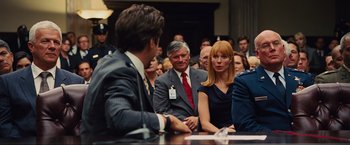 Movie still from “Iron Man 2” (2010), directed by Jon Favreau – A group of people sitting around a table; Medium shot, Over the shoulder angle