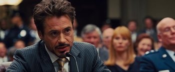 Movie still from “Iron Man 2” (2010), directed by Jon Favreau – A person wearing a suit and tie; Close Up shot, Over the shoulder angle
