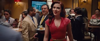 Movie still from “Iron Man 2” (2010), directed by Jon Favreau – A woman in a red dress standing in front of a group of people; Medium shot, Over the shoulder angle