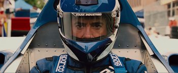 Movie still from “Iron Man 2” (2010), directed by Jon Favreau – A man wearing a racing suit and a helmet; Close Up shot, Low angle