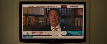 Movie still from “Iron Man 2” (2010), directed by Jon Favreau – A television screen showing a man in a suit and tie; Close Up shot, Over the shoulder angle