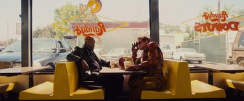 Movie still from “Iron Man 2” (2010), directed by Jon Favreau – Two men sitting at a table in a restaurant; Wide shot, Over the shoulder angle