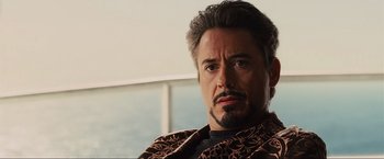 Movie still from “Iron Man 2” (2010), directed by Jon Favreau – A person with a beard and mustache; Close Up shot, Over the shoulder angle