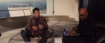 Movie still from “Iron Man 2” (2010), directed by Jon Favreau – Two men sitting on a couch with a glass of wine; Medium shot, Over the shoulder angle