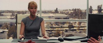 Movie still from “Iron Man 2” (2010), directed by Jon Favreau – A woman sitting at a desk in front of a window; Medium shot, Over the shoulder angle