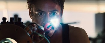 Movie still from “Iron Man 2” (2010), directed by Jon Favreau – A person with a flashlight; Close Up shot, Over the shoulder angle