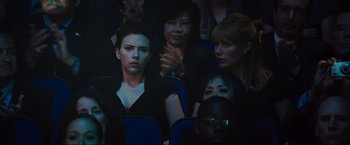 Movie still from “Iron Man 2” (2010), directed by Jon Favreau – A group of people sitting in a theater; Medium shot, Over the shoulder angle