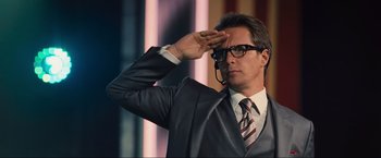 Movie still from “Iron Man 2” (2010), directed by Jon Favreau – A man saluting in a suit and tie; Close Up shot, Low angle