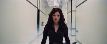 Movie still from “Iron Man 2” (2010), directed by Jon Favreau – A woman with long red curly hair wearing a black dress; Medium shot, Low angle