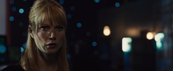 Movie still from “Iron Man 2” (2010), directed by Jon Favreau – A woman with red hair is standing in the dark; Close Up shot, Over the shoulder angle