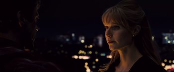 Movie still from “Iron Man 2” (2010), directed by Jon Favreau – A woman is standing in front of a city at night; Close Up shot, Low angle