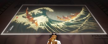 Movie still from “Isle of Dogs” (2018), directed by Wes Anderson – A man in front of a large painting of a wave; Medium shot, Low angle