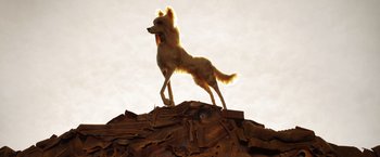 Movie still from “Isle of Dogs” (2018), directed by Wes Anderson – A dog standing on top of a pile of wood; Wide shot, Low angle
