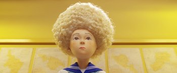 Movie still from “Isle of Dogs” (2018), directed by Wes Anderson – A doll wearing a blonde wig; Close Up shot, Low angle