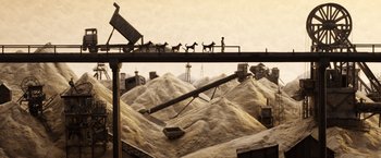 Movie still from “Isle of Dogs” (2018), directed by Wes Anderson – A man standing next to a conveyor belt; Extreme Wide shot, High angle