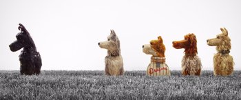 Movie still from “Isle of Dogs” (2018), directed by Wes Anderson – Two stuffed dogs sitting in the grass next to each other; Wide shot, Low angle