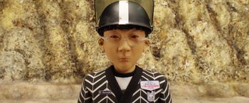Movie still from “Isle of Dogs” (2018), directed by Wes Anderson – A statue of a person wearing a helmet and glasses; Close Up shot, Overhead angle
