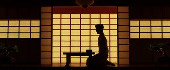 Movie still from “Isle of Dogs” (2018), directed by Wes Anderson – A man kneeling down in front of a window; Extreme Wide shot, Low angle