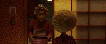 Movie still from “Isle of Dogs” (2018), directed by Wes Anderson – Two people with curlers in their hair looking at each other in front of a mirror; Close Up shot, Over the shoulder angle