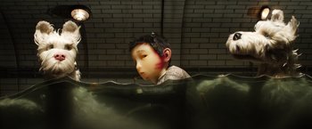 Movie still from “Isle of Dogs” (2018), directed by Wes Anderson – A statue of a boy with a red nose is submerged in water; Close Up shot, Low angle