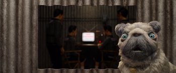 Movie still from “Isle of Dogs” (2018), directed by Wes Anderson – A group of people sitting in front of a television; Medium shot, Over the shoulder angle