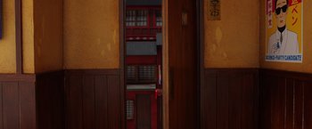 Movie still from “Isle of Dogs” (2018), directed by Wes Anderson – An open door to an asian style building; Extreme Wide shot, Overhead angle