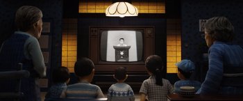 Movie still from “Isle of Dogs” (2018), directed by Wes Anderson – Three children watching television in a room; Wide shot, Low angle