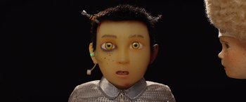 Movie still from “Isle of Dogs” (2018), directed by Wes Anderson – An image of a boy with yellow eyes; Close Up shot, Overhead angle