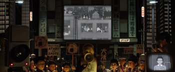 Movie still from “Isle of Dogs” (2018), directed by Wes Anderson – A group of people standing in front of a screen; Extreme Wide shot, Low angle