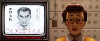 Movie still from “Isle of Dogs” (2018), directed by Wes Anderson – A person wearing headphones next to a television; Close Up shot, Low angle